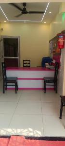 a pink counter in a store with two chairs at Mukherjee Lodge in Rāmpur Hāt