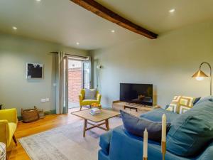 a living room with a blue couch and a tv at 3 Bed in Saxmundham oc-89691 in Aldringham