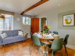 a dining room with a table and a couch at 3 Bed in Saxmundham oc-89691 in Aldringham