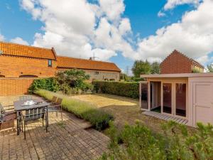 a garden with a table and chairs and a building at 3 Bed in Saxmundham oc-89691 in Aldringham