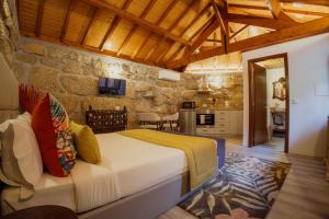 a bedroom with a bed and a stone wall at Refúgios da Natureza in Entre-os-Rios