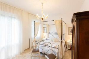 a bedroom with a bed and two chairs and a chandelier at VILLA MAGNOLIA in Cavallino-Treporti