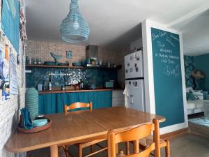 a kitchen with a wooden table and a refrigerator at CASA BOHO your happy place in Calheta in Calheta