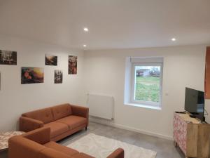 a living room with a couch and a television at L'instant Vosgien in Laveline-devant-Bruyères +4 photos