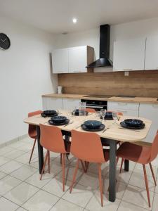 a kitchen with a wooden table and chairs at L'instant Vosgien in Laveline-devant-Bruyères