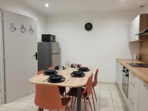a kitchen with a table with chairs and a refrigerator at L'instant Vosgien in Laveline-devant-Bruyères