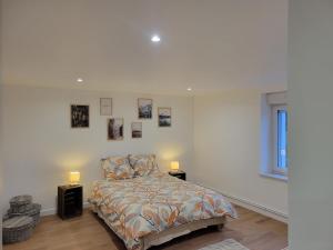 a white bedroom with a bed and two lamps at L'instant Vosgien in Laveline-devant-Bruyères