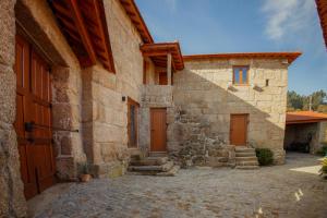 a stone building with two wooden doors and stairs at Refúgios da Natureza in Entre-os-Rios