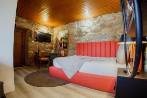 a bedroom with a large bed and a stone wall at Refúgios da Natureza in Entre-os-Rios