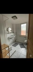 a white bathroom with a sink and a window at Haus Cronenberg im Harz in Wernigerode