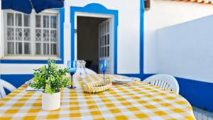 a table with a yellow and white checkered table cloth at A Casa dos Avós in Pêra