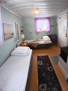 a small room with two beds and a table at Årsunda Strandbad Sjösunda vandrarhem in Årsunda