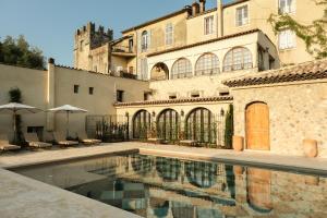 a courtyard with a swimming pool in front of a building at L'Abbaye Hôtel in La Colle-sur-Loup