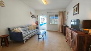a living room with a couch and a tv at A Casa dos Avós in Pêra