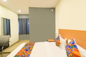 a bedroom with a bed with a wooden headboard at FabHotel Vedhanshi in Hyderabad