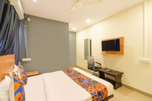 a hotel room with a bed and a tv at FabHotel Vedhanshi in Hyderabad +27 photos