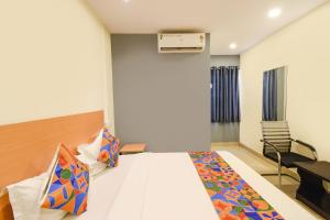 a hotel room with a bed and a desk at FabHotel Vedhanshi in Hyderabad