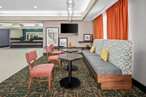 a living room with a couch and a table and chairs at Hampton Inn Bloomington West in Bloomington