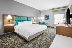 a hotel room with a bed and a television at Hampton Inn Bloomington West in Bloomington +33 photos