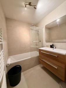 a bathroom with a tub and a sink and a shower at Le Thylleul - Centre-ville, parking in Albertville