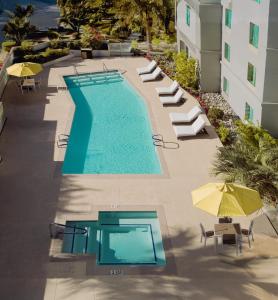 an overhead view of a swimming pool with chairs and umbrellas at Hampton Inn & Suites Palm Desert in Palm Desert