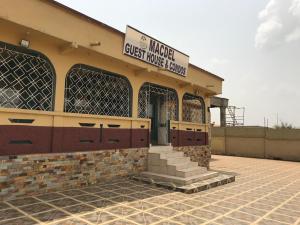 a building with a gate and a guest house at Macdel Guesthouse And Condos in Kumasi