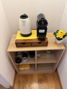 a coffeemaker on a wooden shelf with a coffee maker at Independent house private garden in Milan