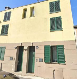 a building with green shutters on the side of it at Independent house private garden in Milan