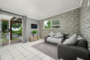 a living room with a couch and a brick wall at 302 On Old Sea View Road Chelsea in Port Elizabeth