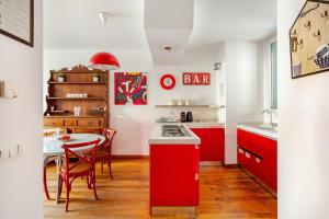 a kitchen with red cabinets and a table with a red counter at Independent house private garden in Milan