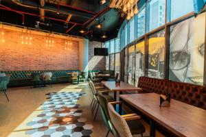 a restaurant with wooden tables and chairs and a brick wall at DoubleTree by Hilton Dubai Port Saeed in Dubai +131 photos