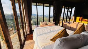 a bedroom with two beds in a room with large windows at The Rusty Villa in Hatton