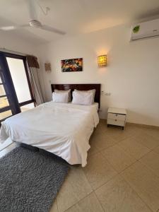 a bedroom with a large bed with white sheets at Ocean Crown Apartments in Mombasa +41 photos