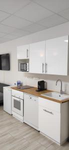 a kitchen with white cabinets and a sink at Eleonoras Ferienwohnung in Würzburg Stadt mit Terrasse und eigenen Parkplätzen vor der Tür, für große Gruppen bis zu 13 Personen geeignet in Würzburg
