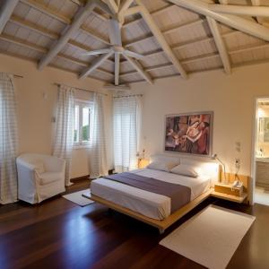 a bedroom with a large bed and a ceiling at Alpha Luxury Villa - Private Pool & VIP Services in Platanias