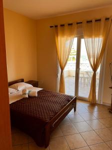 a bedroom with a bed and a sliding glass door at Geomelos Theodoros Apartments in Chios
