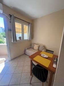 a living room with a table and a couch at Geomelos Theodoros Apartments in Chios