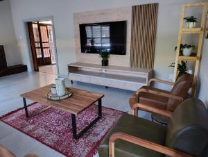 a living room with a couch and a table and a tv at The Nelsons on 99 Smith in Dundee