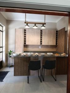 a kitchen with a counter with plates and chairs at The Nelsons on 99 Smith in Dundee