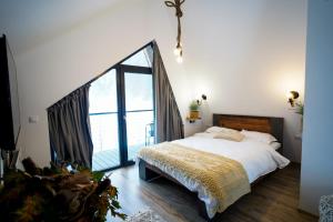 a bedroom with a large bed and a large window at Chalet Alex in Fundata
