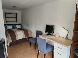 a bedroom with a bed and a desk with a computer at Gemenc - Lak in Baja