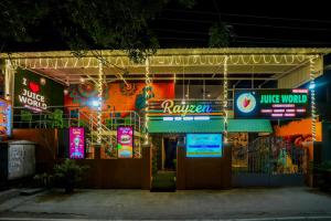 a restaurant with neon signs in front of it at night at Rayzen Stays & Backpackers Hostel in Chennai