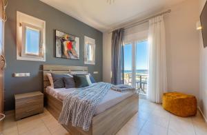a bedroom with a bed with a view of the ocean at Alkis Dream Villa with Jacuzzi in Kos