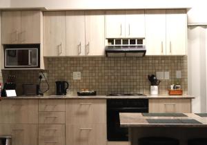 a kitchen with white cabinets and a stove top oven at Ama's Self Catering in Windhoek