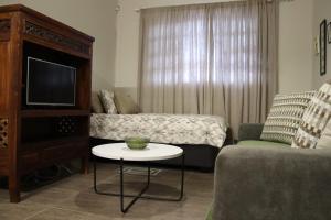 a living room with a bed and a small table at Ama's Self Catering in Windhoek