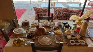 a table with food on it with a table at Peaceful Luxury Camp in Merzouga +29 photos