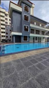 a building with a swimming pool in front of a building at LionsGate Homes in Nakuru