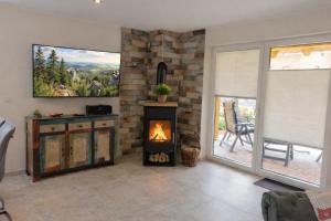 a living room with a fireplace and a table at Premium-Plus-Ferienhaus Skadi I in Hasselfelde +30 photos