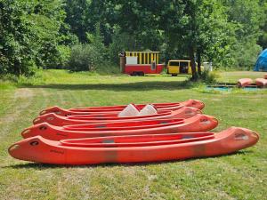 a row of red canoes sitting on the grass at Kemp Karvánky in Dráchov