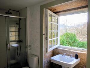 a bathroom with a toilet and a sink and a window at Quinta da Coutada - AgroTurismo in Arcos de Valdevez +42 photos